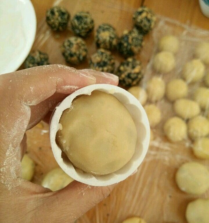 五仁馅月饼,月饼模具放熟粉进去转一圈,再倒出来。手上沾点熟粉也把月饼坯抹一下,然后放到模具里。