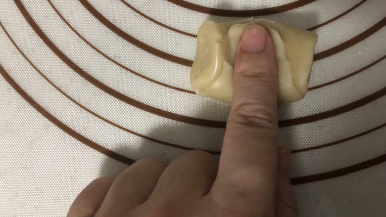 椒盐芝麻牛舌饼,取一个面卷,用手指在中间按一下