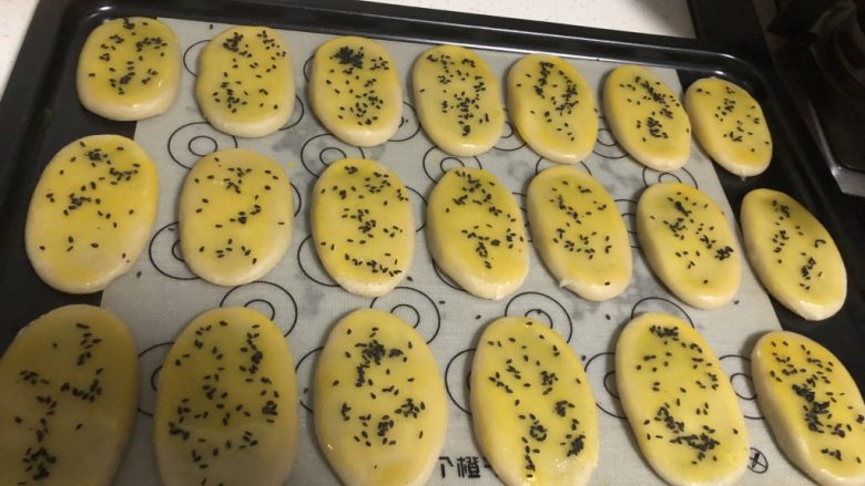 椒盐芝麻牛舌饼,放入烤盘,刷蛋黄液,撒芝麻