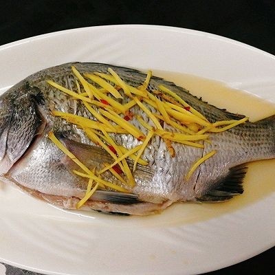 年年有鱼--清蒸海鲫鱼,先倒<a style='color:red;display:inline-block;' href='/shicai/ 718'>料酒</a>至鱼的全身,姜丝铺在鱼身上,腌制5分钟左右