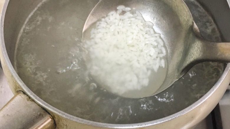 宝宝辅食8M➕:南瓜蛋黄十倍粥,水倒入锅中煮开后放米,大火煮两分钟后转小火煮二十分钟