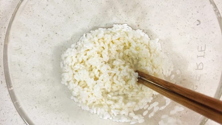 宝宝辅食8M➕:南瓜蛋黄十倍粥,淘洗干净后➕入几滴核桃油并搅拌均匀(提前浸泡能够让米充分吸收水分,放油可以使米粒在下锅的时候充分吸收周围的热水,更容易使米粒煮开花,同时粥也会更棉滑。)