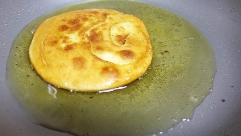 椒盐油饼,把饼子放进锅中，中小火加热煎制。