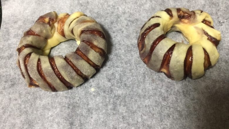 最爱豆沙甜圈圈,放入烤盘,利用烤箱再次发酵,为了避免面包胚表皮干硬,烤箱事先预热了45度,并且烤箱底部放入一盘清水