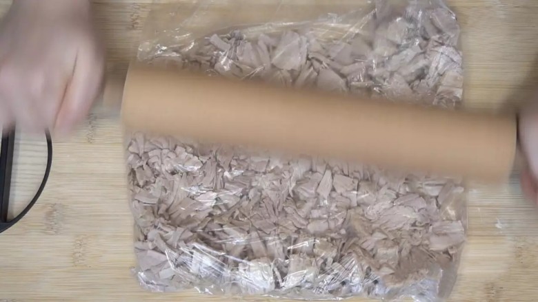 自制肉松,煮好后沥干水,装进保鲜袋,用擀面杖先擀碎,再拍打松