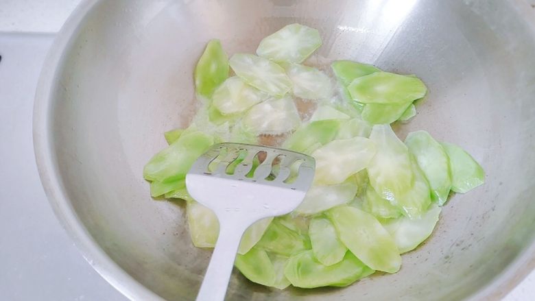 红椒莴苣炒肉片,油六七分热的时候,倒入莴苣,翻炒。