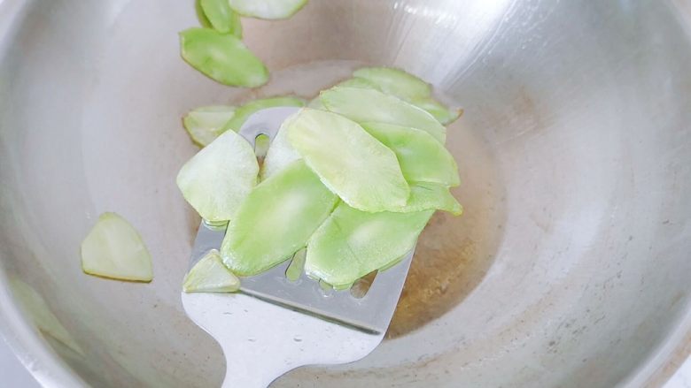红椒莴苣炒肉片,莴苣断生后,把莴苣捞起来装盆,有漏油的锅铲最好。要是没有那种锅铲,就把锅倾斜一边,再把莴苣弄到没有油的那一边,再盛。