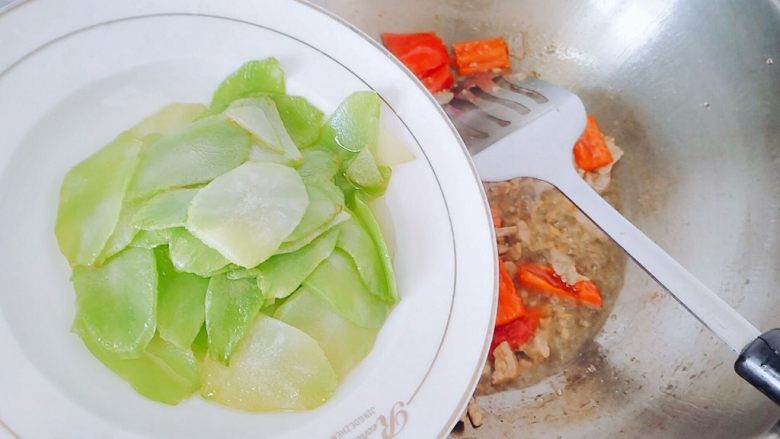 红椒莴苣炒肉片,红辣椒断生,下莴苣,继续翻炒。