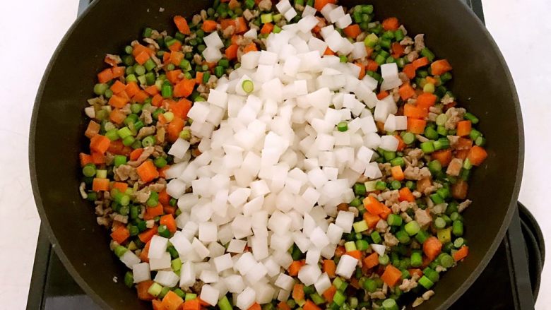 肉末三丁盖浇饭,加入萝卜丁,翻炒1分钟