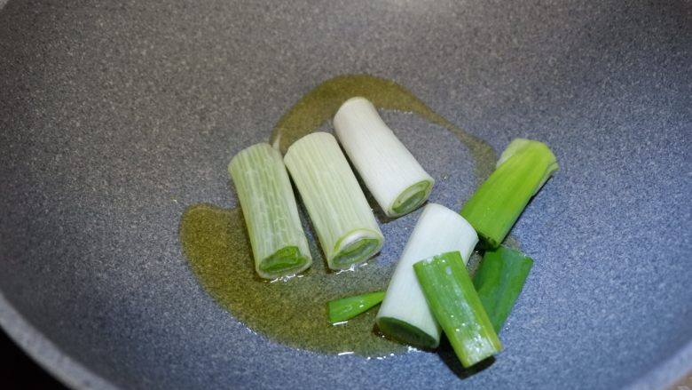 葱烧蘑菇,传统鲁菜,锅中放油,下入葱段,炒出香味至葱段微焦