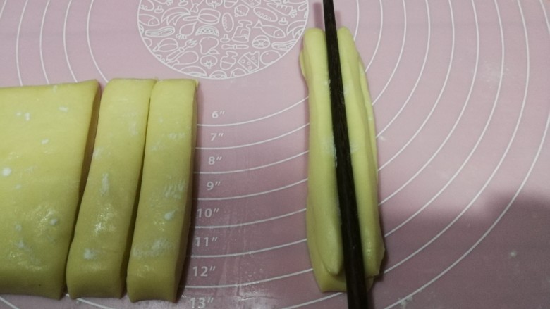自制安心油条,两根重叠,用一根筷子在中间压一道印痕,反过来也压一下,两手分别拉着两端将面条生坯抻长至约20cm长