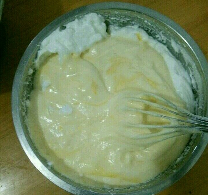 酸奶淋面蛋糕,然后倒回蛋白糊,继续翻拌至顺滑。把蛋糕糊倒进模具里,在垂直桌面20里面的距离,震一下模具,震出大气泡。