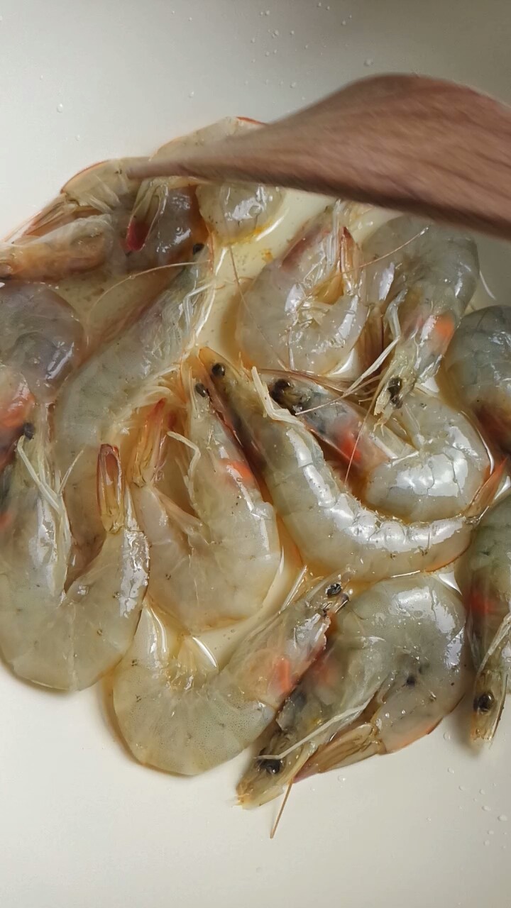避风塘炒虾,用铲子压一压虾头,压出红油
