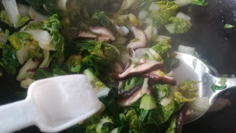 香菇炒青菜,加入一小勺盐调味。