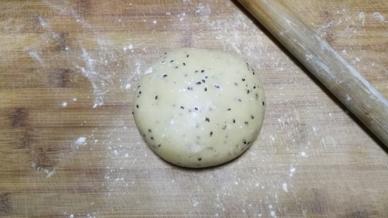 年味~花式炸麻叶,松弛两小时后取出面团,放在大的面板上,面板撒适量面粉防粘,然后用擀面杖将面团慢慢推开推大