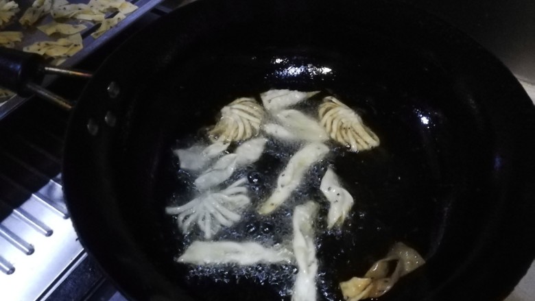 年味~花式炸麻叶,锅中加入适量玉米油,大火烧至筷子蘸进去起大泡后转小火,将做好的麻叶生坯依次放入炸制,两面金黄即捞出