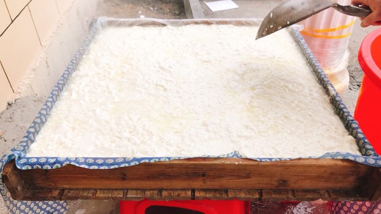 豆腐的形成,再把豆腐装入磨具中(磨具要用湿的纱布垫底)