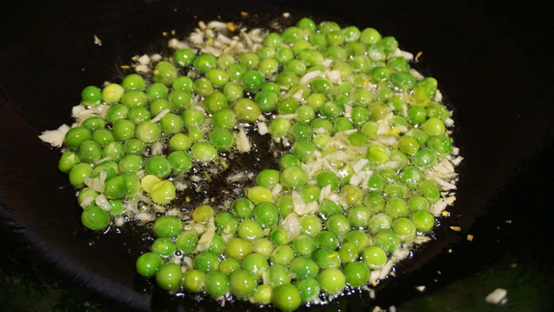花甲豌豆,然后倒入煮熟的豌豆粒翻炒均匀