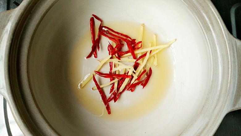 酸菜丸子粉丝煲,锅中适量的油,放入姜丝和干辣椒丝爆出香味儿。