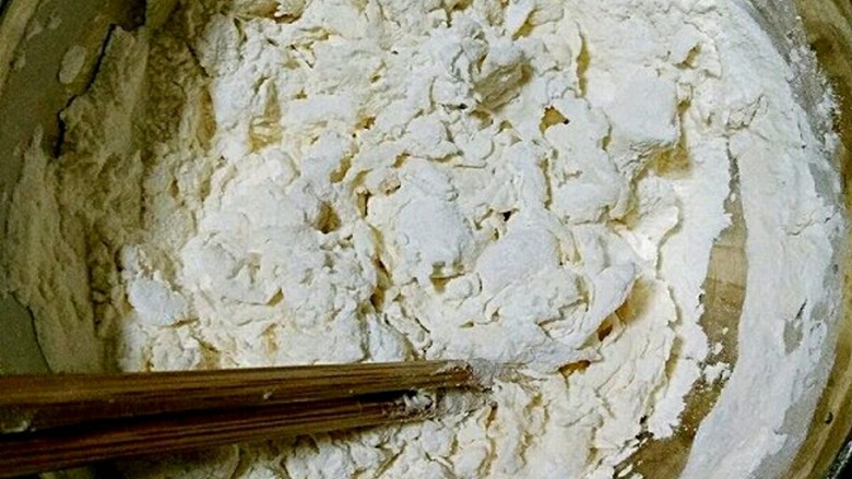 朴素的混汤手擀面,在面粉中加入2克盐,并少量多次加入清水,用筷子搅拌成雪花状。
