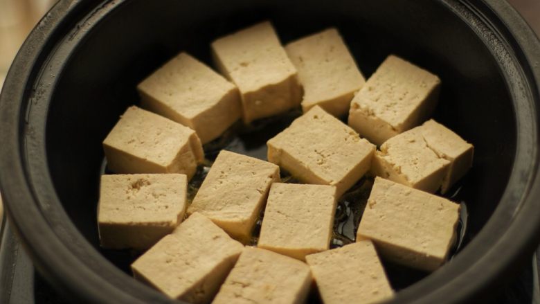 酿豆腐,锅里倒油,将有肉馅的一面朝下摆入锅里,小火慢煎