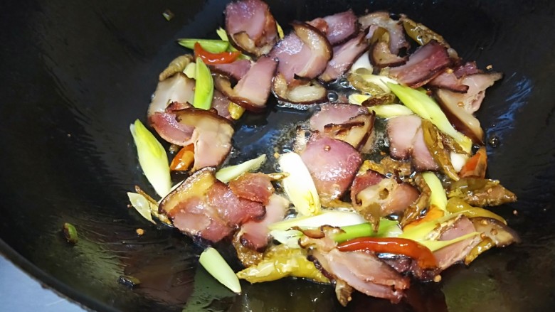 泡椒炒腊肉,先放入蒜苗白炒均匀。