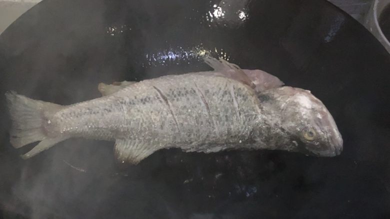 红烧鲈鱼,油锅烧快冒烟的时候,放入鱼,不要动,等一面煎金黄了翻面