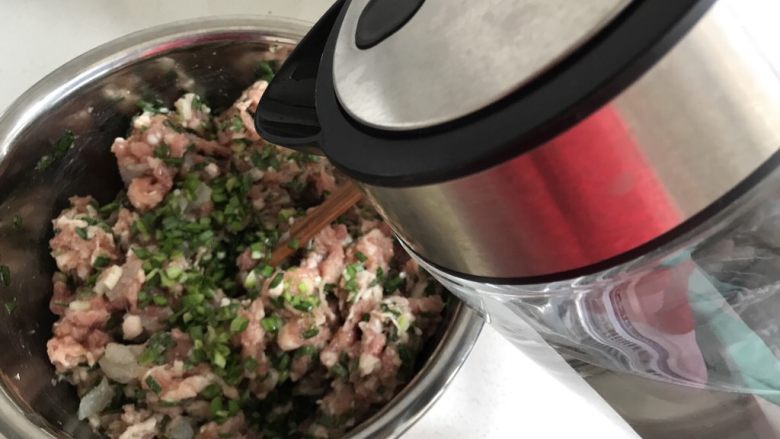 鲜肉虾仁韭菜小馄炖,韭菜加入,顺时针搅拌均匀,然后加入一点点水,这样可以使肉馅容易成团,不易散开,包的时候也好包。