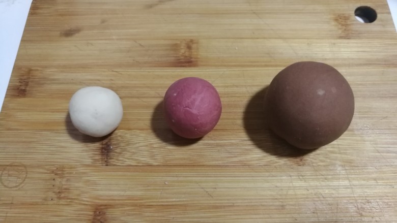 大黄狗豆沙包,这样得到三份不同颜色的面团，盖上保鲜膜发酵