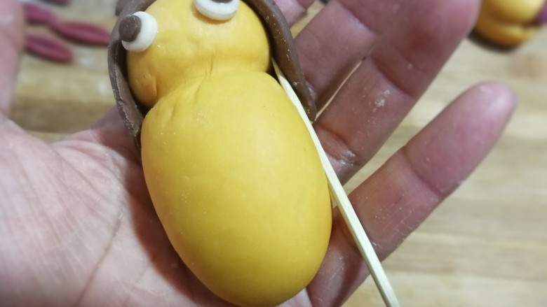 大黄狗豆沙包,接着在下部分两侧用竹签压出两道印