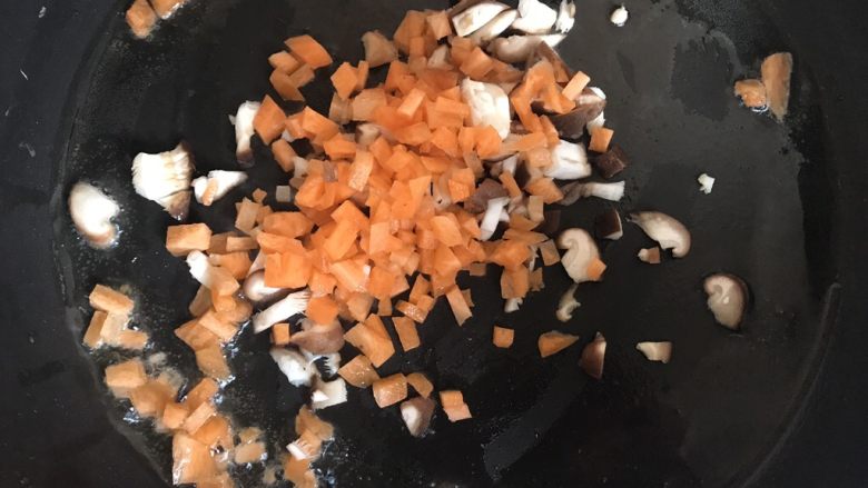 菠萝造型炒饭,锅中放入少许油,倒入胡萝卜和香菇丁翻炒