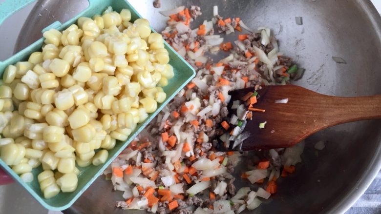 让炒饭粒粒分明的诀窍➕牛肉玉米黄金炒饭,加入玉米粒翻炒均匀，今天阿晨用的熟玉米，如果大家用的生玉米粒，可以事先焯水烫熟也可以直接下锅但要多翻炒一会并点水