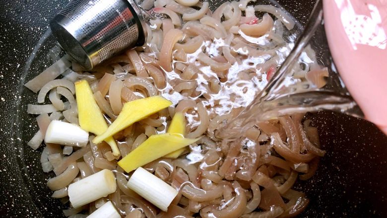 好滋味皮冻,把肉皮重新放到锅里,放入剩下的一半大葱和姜片,放入香料盒,倒入1500ml水,开大火把水烧开