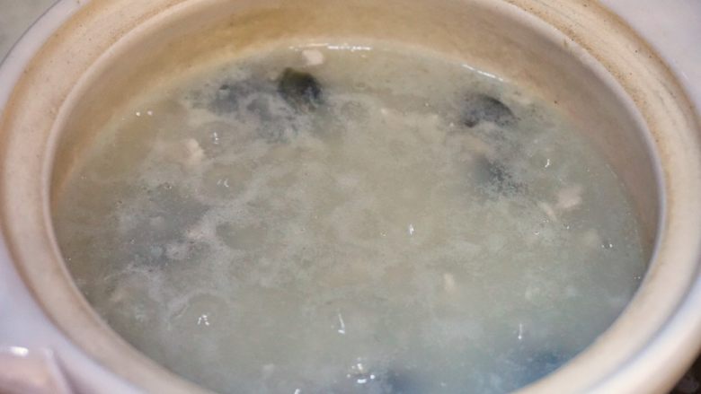 皮蛋瘦肉粥,等粥已经基本熬成,放入瘦肉丁搅拌一下,很快就变色说明肉已经熟了。
