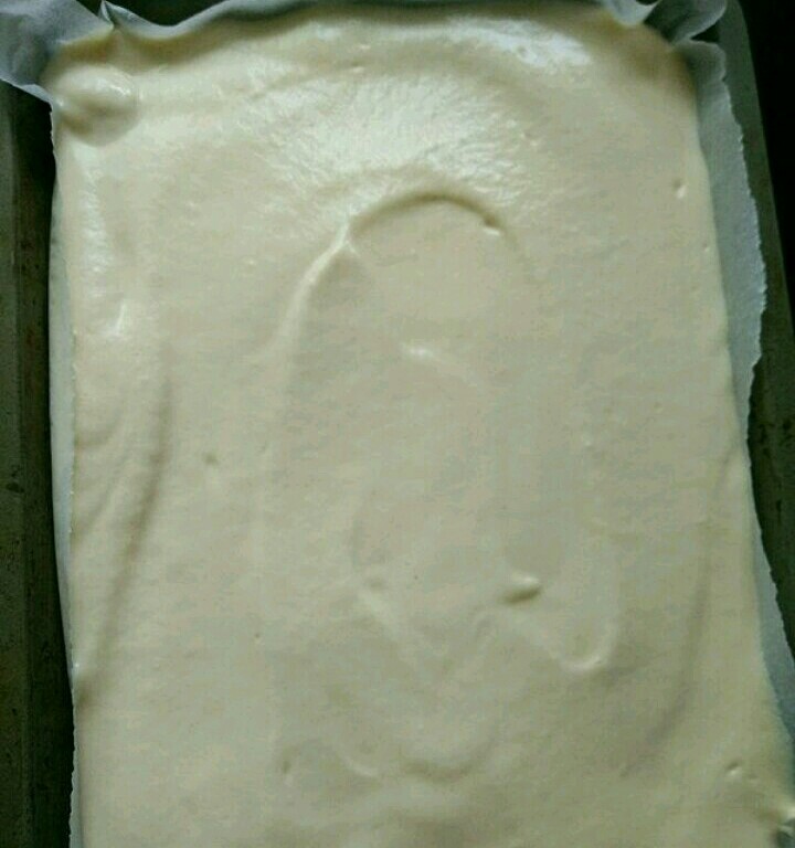 紫薯蛋糕卷,把蛋糕糊倒进烤盘里,垂直桌面用力震一下,震出气泡。