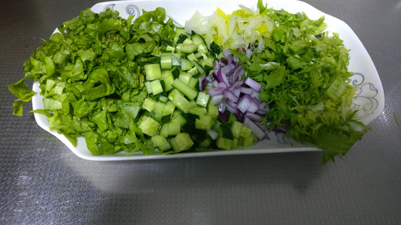 缓解春节油腻清口营养东北饭包,将洗好的生菜,黄瓜,洋葱,大葱,苦苣,香菜等切成小丁备用