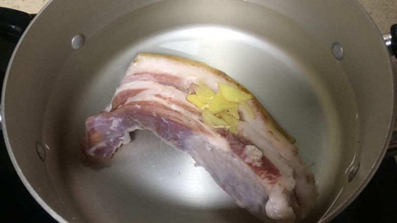 渝派回锅肉,菜市场买回新鲜五花肉已烧皮去毛洗净,锅里加入清水和<a style='color:red;display:inline-block;' href='/shicai/ 2802'>老姜</a>,煮五花肉