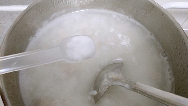 咸口益气补脏皮蛋下火粥,放入猪肉丁,然后加入盐进行调味