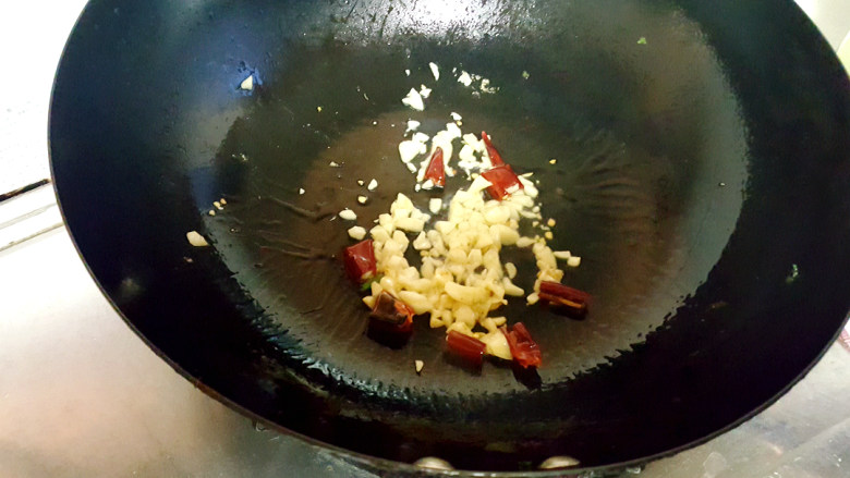 ~粉丝蟹煲,放入蒜,辣椒放入油中煸香。