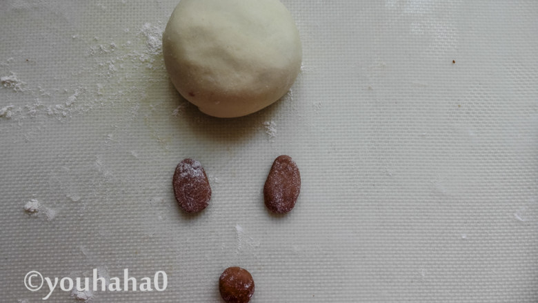 小猪豆沙包,包好的豆沙包稍微压扁一点,取一点面团揉入少许的<a style='color:red;display:inline-block;' href='/shicai/ 920'>可可粉</a>,可可面团分出3的小面剂子,2个擀成椭圆形,一个捏成圆形