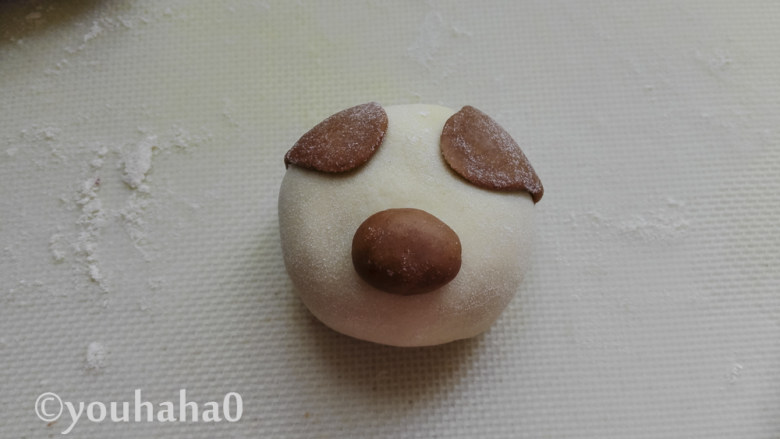 小猪豆沙包,圆形的面团刷一点点水,粘在豆沙包的中下部,作为小猪的鼻子