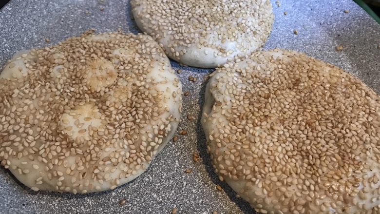 老北京烧饼夹肉,平底锅底锅或电饼档上抹上少许油,放上做好的饼,盖上锅盖小火慢煎