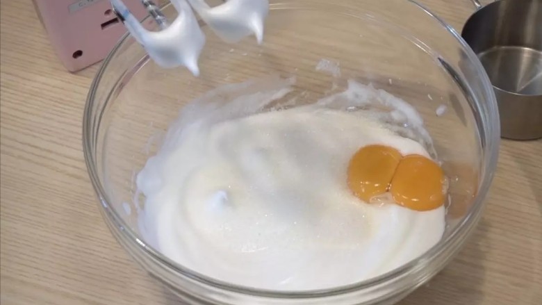 树莓慕斯,蛋糕胚:蛋黄蛋白分离,打发蛋白,蛋白出现有纹路后,倒入1/2细砂糖,继续打发。9分打发(提起打蛋头有尖尖角)后,加入细砂糖和蛋黄,继续打发1-2分钟
