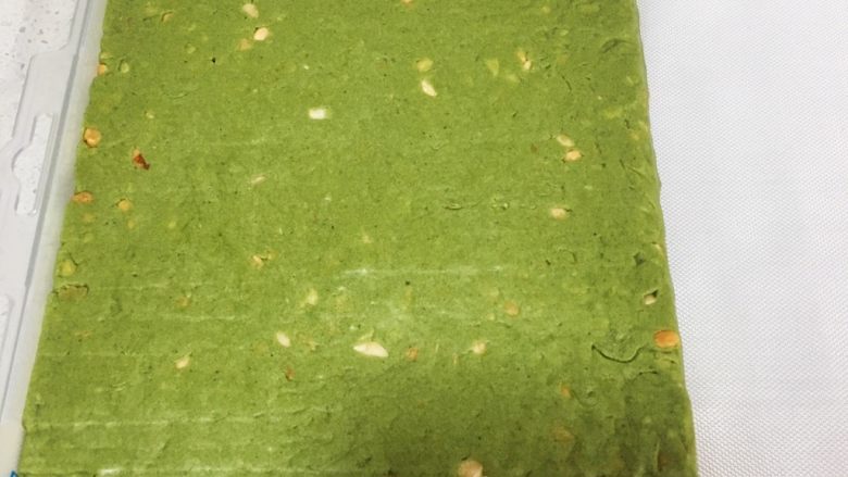 抹茶味牛轧糖,放入不粘金盘里整形,压的越整齐,切出来的成品就越好看
