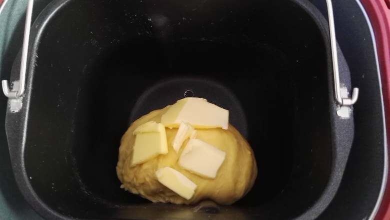 卷卷椰蓉包,面团揉出薄膜时,加入软化的黄油,继续揉面。