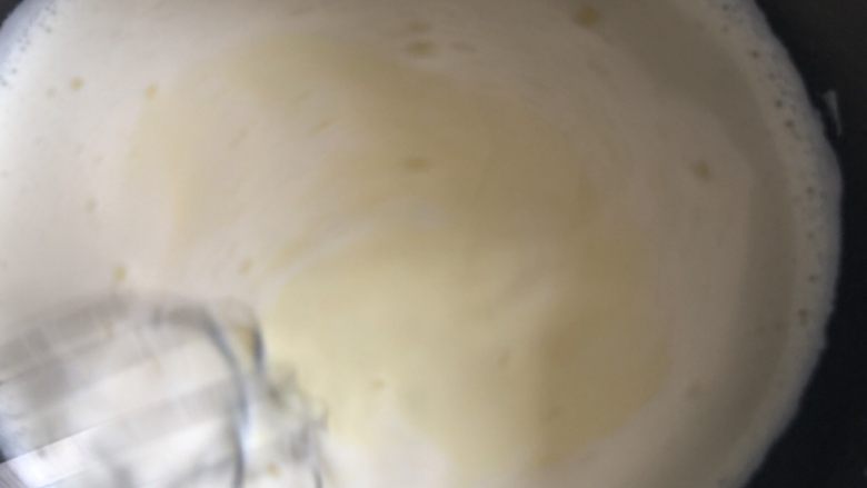 爆浆奶盖蛋糕,搅拌好的牛奶蛋黄液重新倒入奶锅,小火加热,一边用手动打蛋器不停搅拌,慢慢变凝固离火,别熬的太干,太干会导致后面淋面比较闹心