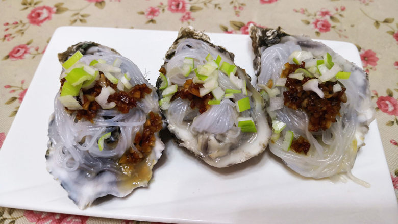 蒜蓉生蚝,点一点一品鲜,再撒上葱花,最后烧上热油,就可以上桌啦。