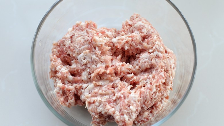 鲜肉包子(一次发酵法),猪肉剁成肉馅放入容器中,肉馅要剁的碎一些