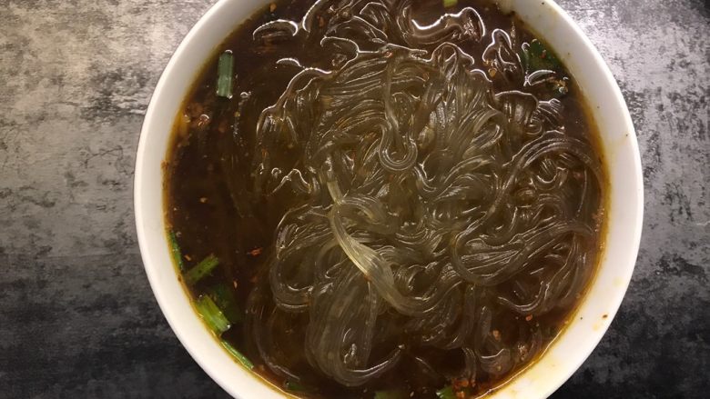 快手酸辣粉,煮熟后捞加入调好料汁的碗中,加入花生米、香菜和榨菜,吃之前搅拌均匀