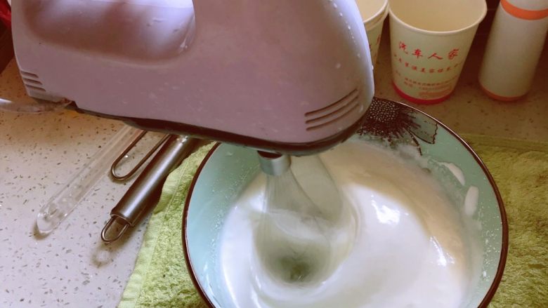 电饭煲蒸蛋糕,打到肥皂泡状时第二次加15g细砂糖,继续低速打,打到有纹路出现的时候第三次加糖(剩下的糖都放进去好了),并且把醋一起倒入,继续打,可以转为高速打
